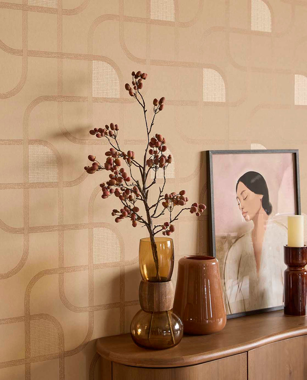 Looping Line wallpaper in peach with copper lines behind vases and artwork on a sideboard
