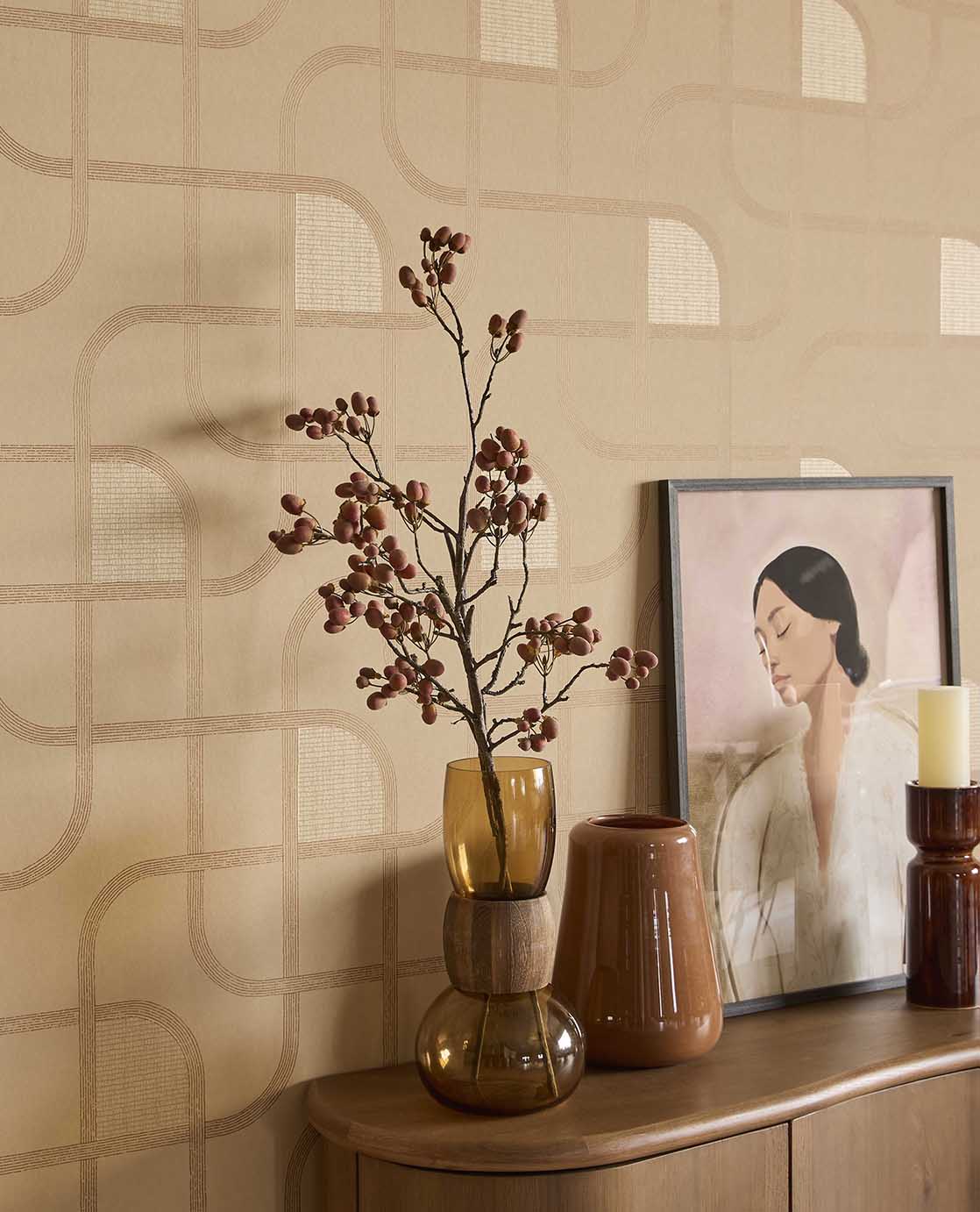 Looping Line wallpaper in peach with copper lines behind vases and artwork on a sideboard