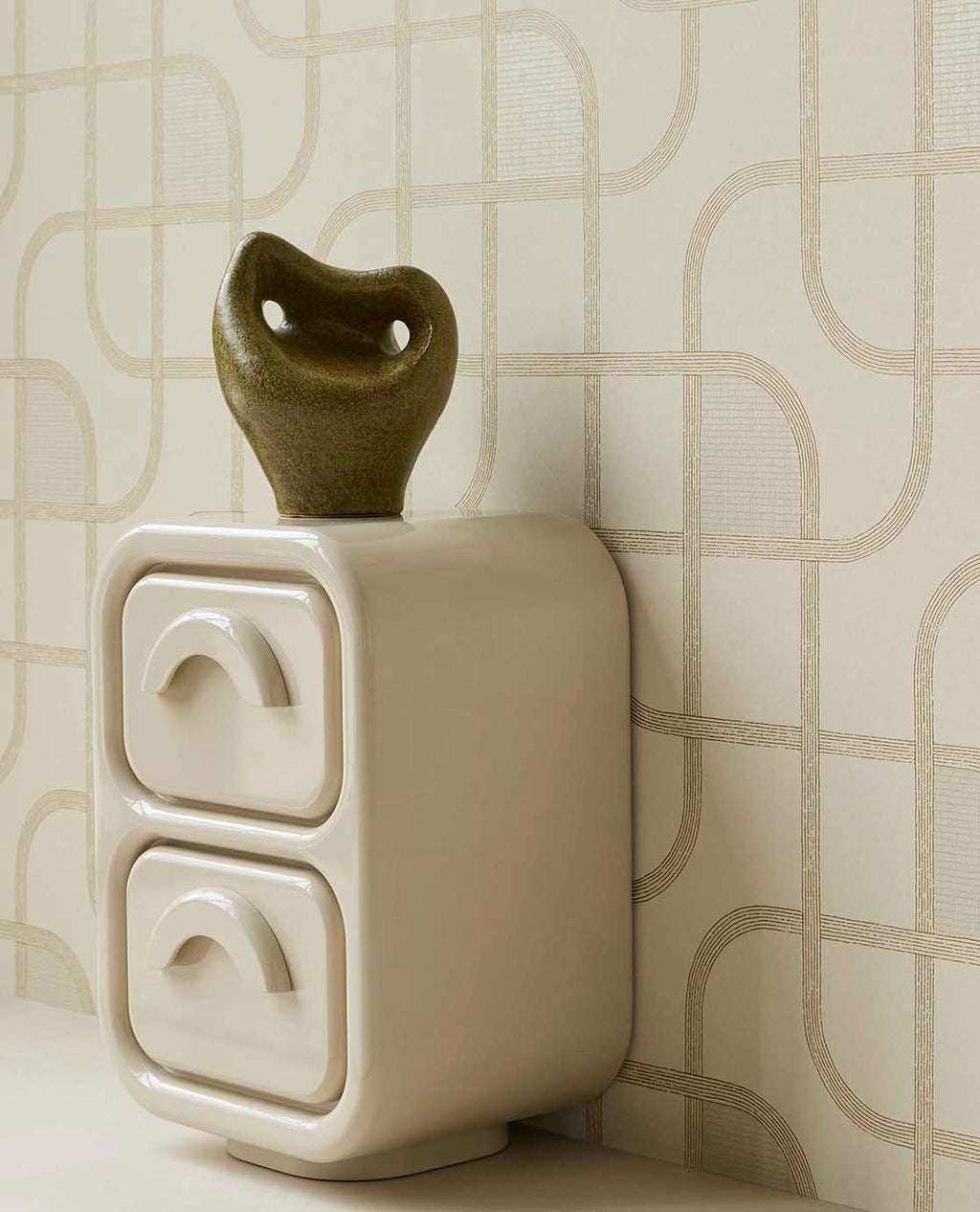 Looping Line wallpaper in green with gold lines, close-up behind a ceramic sculpture