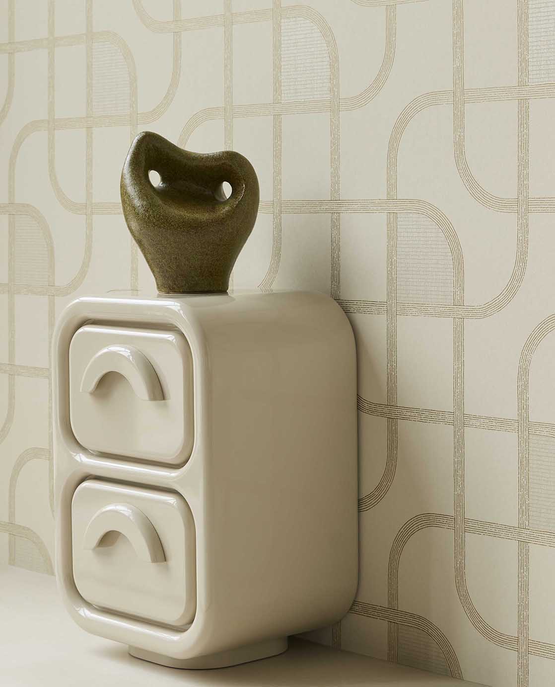 Looping Line wallpaper in green with gold lines, close-up behind a ceramic sculpture