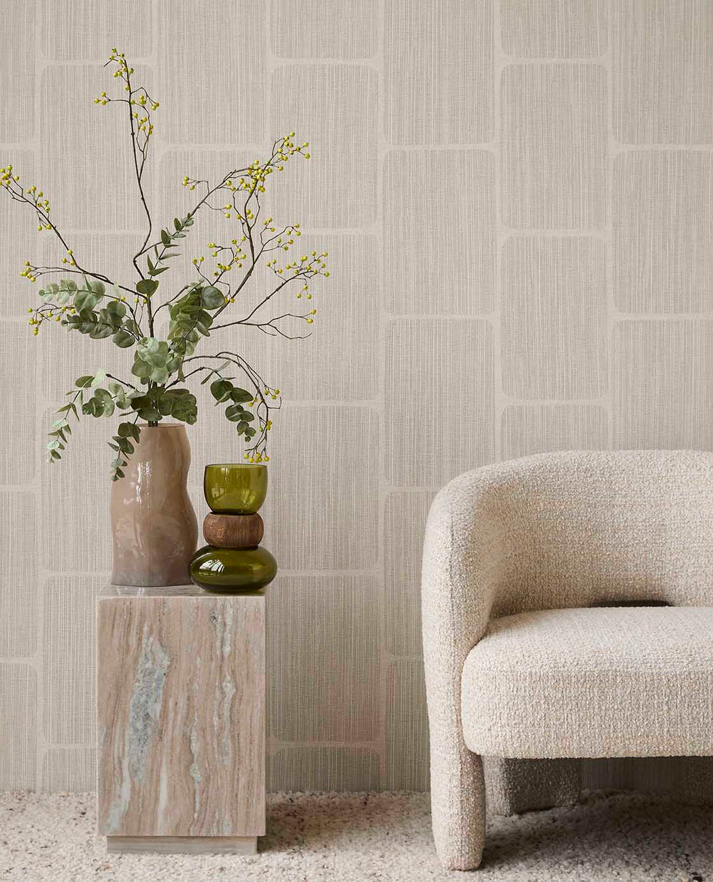Woven Grid wallpaper in grey behind a boucle armchair and stone plinth
