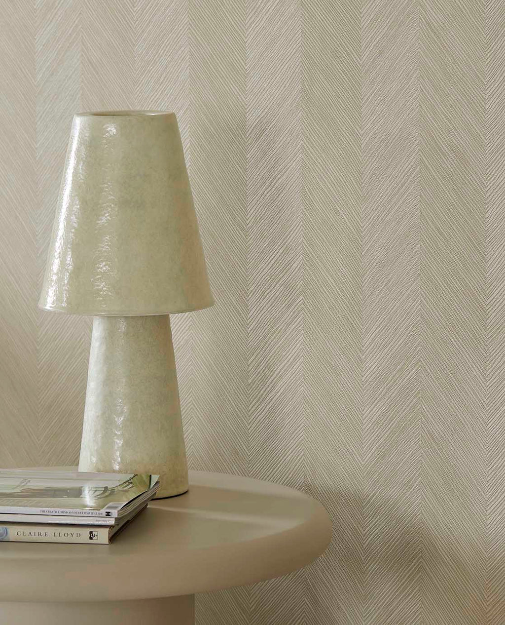 Woven Herringbone wallpaper in beige, close-up behind a ceramic table lamp