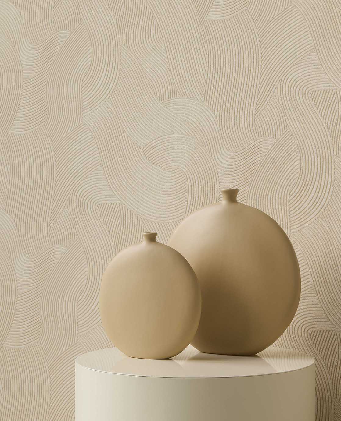 Raked Sand wallpaper in beige behind two round vases on a plinth