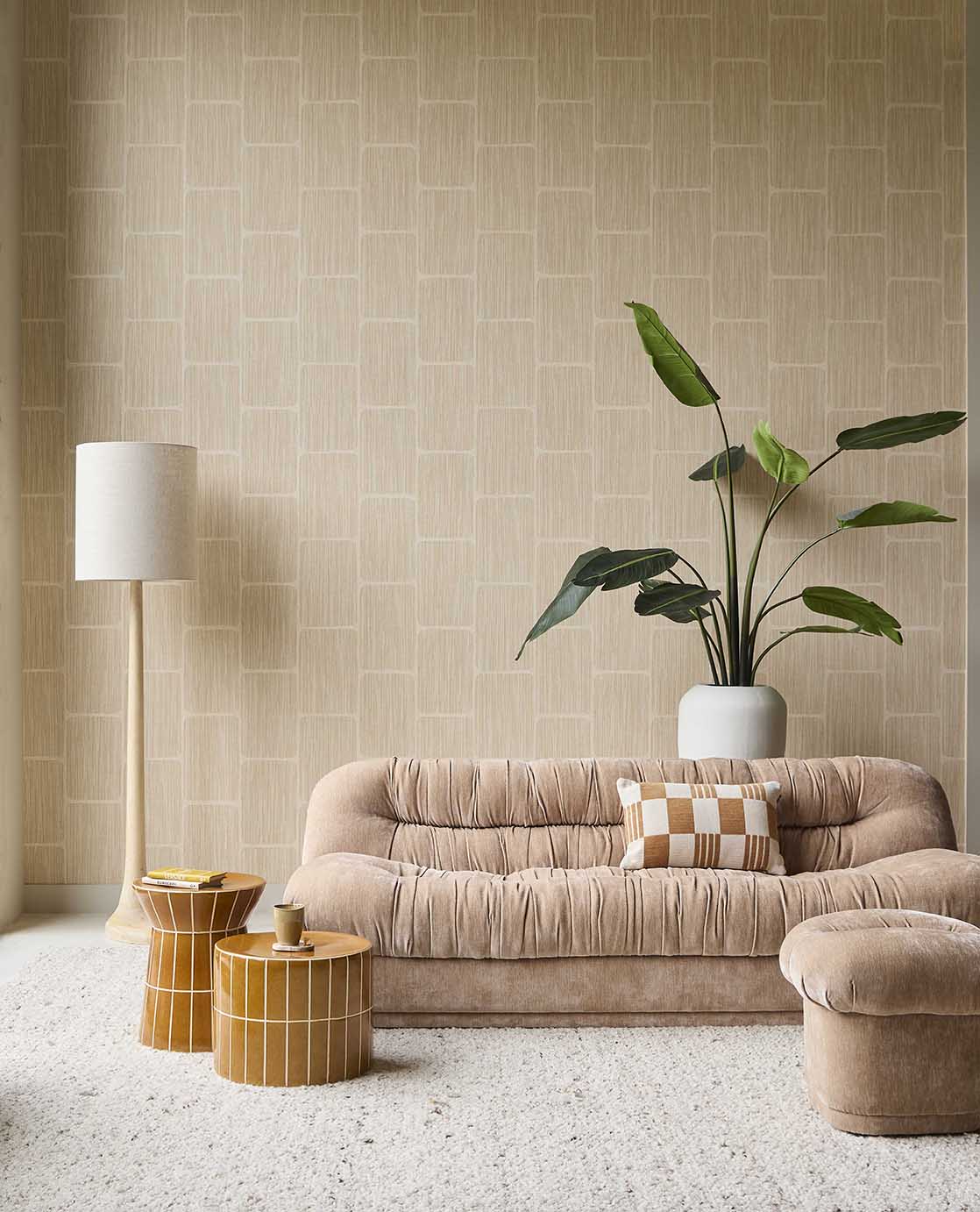 Woven Grid wallpaper in beige in a living room with a velvet sofa, floor lamp and plant
