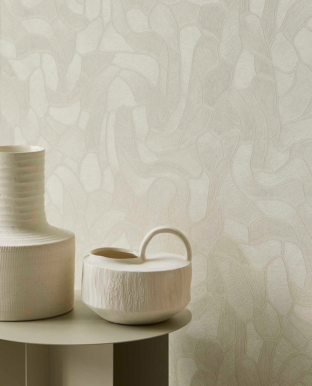 Pebble Relief wallpaper in light green behind white ceramic vases