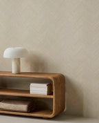 Woven Herringbone wallpaper in pale linen beige behind a curved timber console and lamp