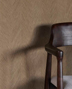 Woven Herringbone wallpaper in taupe beside a dark timber dining chair