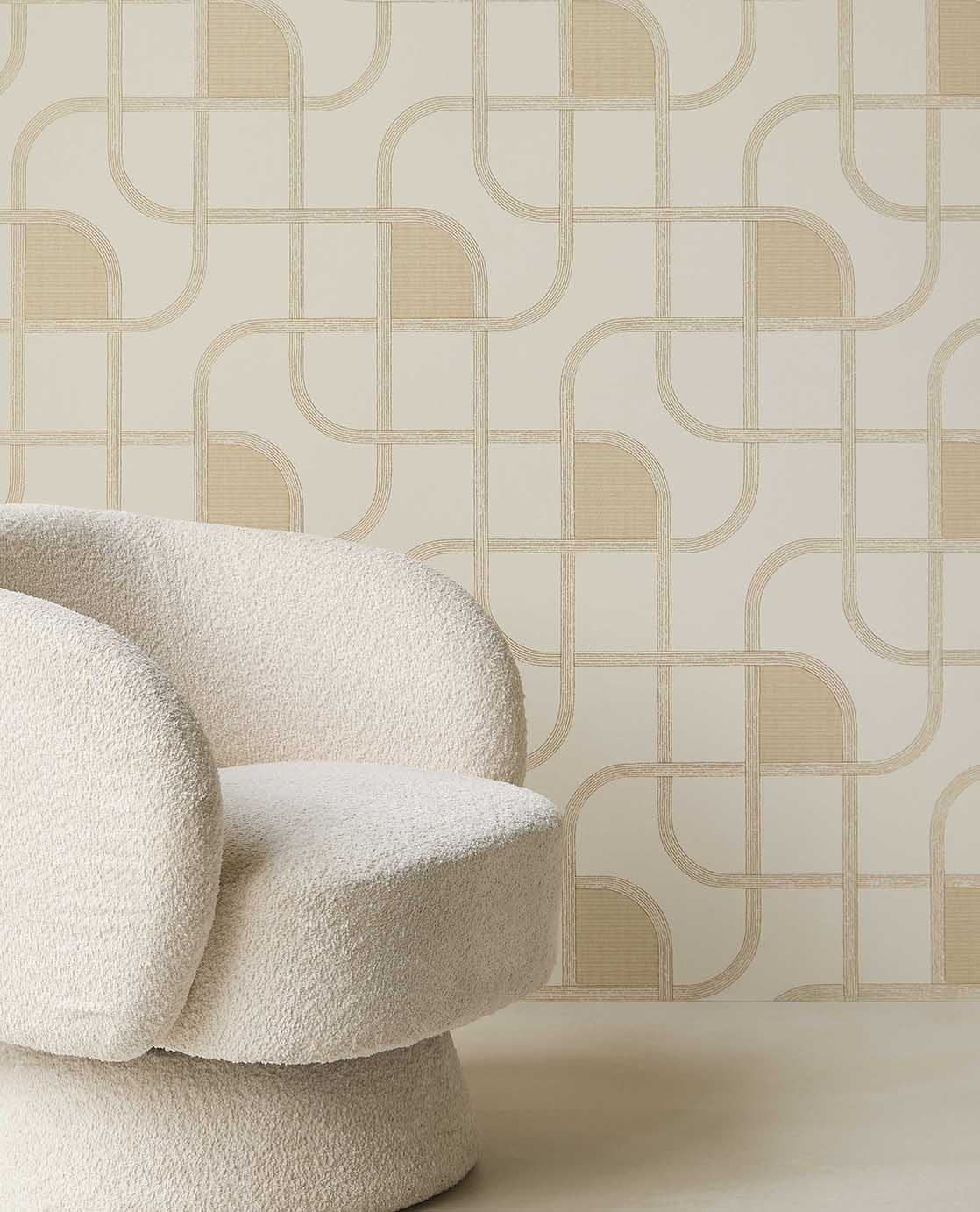 Looping Line wallpaper in cream with gold lines behind a white boucle armchair