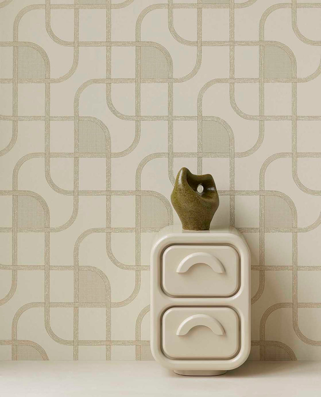 Looping Line wallpaper in green with gold lines behind a white bedside cabinet
