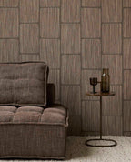 Woven Grid wallpaper in dark brown behind a brown sofa and side table