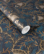 Banksia Bloom wallpaper by Eijffinger in dark teal navy with copper-gold floral motif, shown on a partially unrolled roll