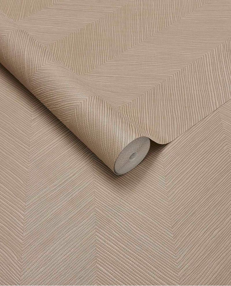 Woven Herringbone wallpaper by Eijffinger in soft tan, linen-textured herringbone shown as a partly unrolled roll