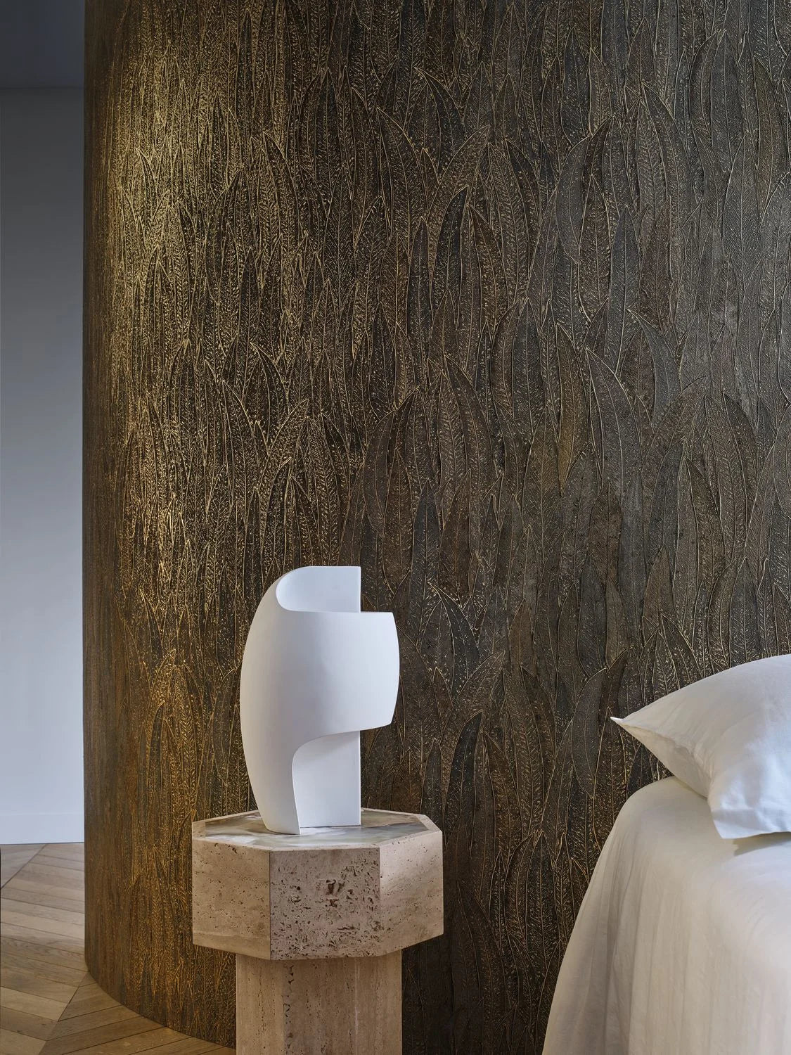 Cinerea Leaves wallpaper by Casamance in Charcoal and Gold, gilded leaves on a curved wall beside a pale stone bust