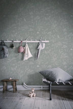 Hollie wallpaper by Sandberg in sage green woodland print behind a peg rail and metal daybed in a kids room