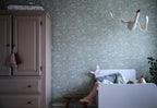 Hollie wallpaper by Sandberg in sage green woodland print in a nursery with toddler bed and dusty pink wardrobe