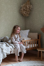 Hollie wallpaper by Sandberg in sage green woodland print in a cosy child bedroom corner with wooden cot bed