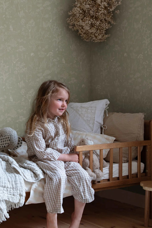 Hollie wallpaper by Sandberg in sage green woodland print in a cosy child bedroom corner with wooden cot bed