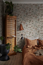 Linda wallpaper by Sandberg in soft greige in a bedroom with rust linen bedding and a tall wood filing chest
