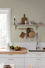 Sigfrid wallpaper by Sandberg in soft green, styled in a bright kitchen above a wooden benchtop with hanging boards and baskets