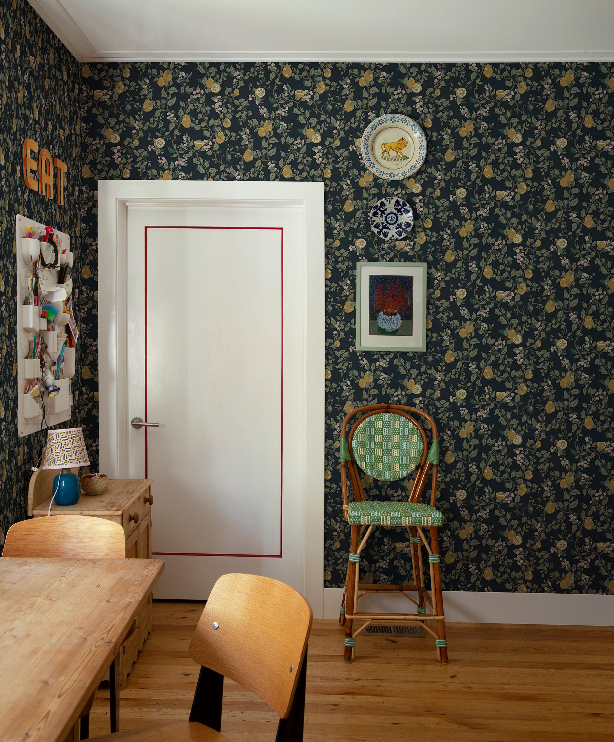 Kvitten wallpaper by Sandberg, navy quince design in a dining room with a white door and rattan bistro chair