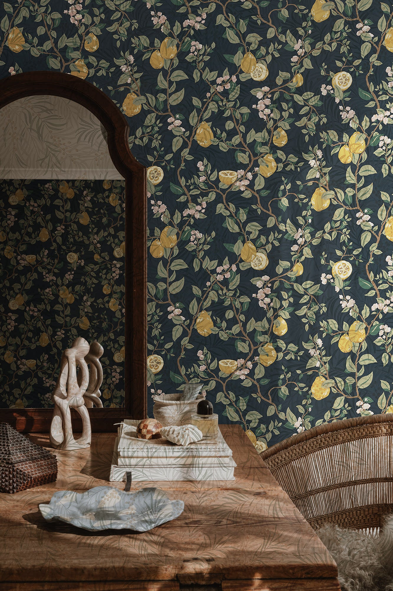 Kvitten wallpaper by Sandberg, navy quince-branch design styled behind a wooden dressing table with an arched mirror