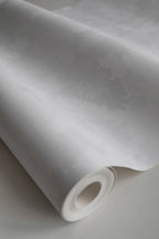 Raphael wallpaper by Sandberg, close-up of a part-rolled roll in tonal white showing the subtle oak-tree relief