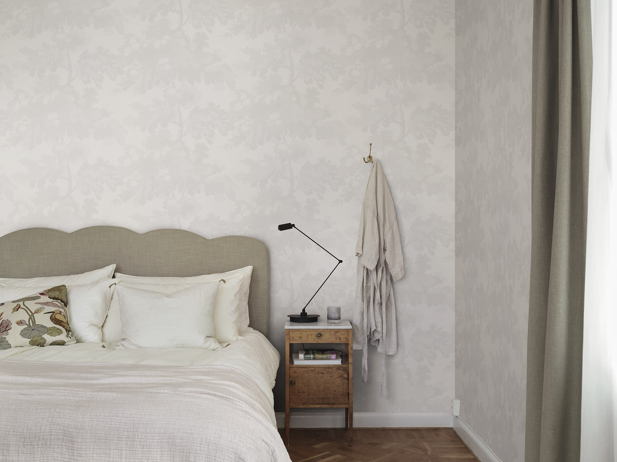 Raphael wallpaper by Sandberg in tonal white oak-tree print in a calm bedroom with a linen headboard and robe hook