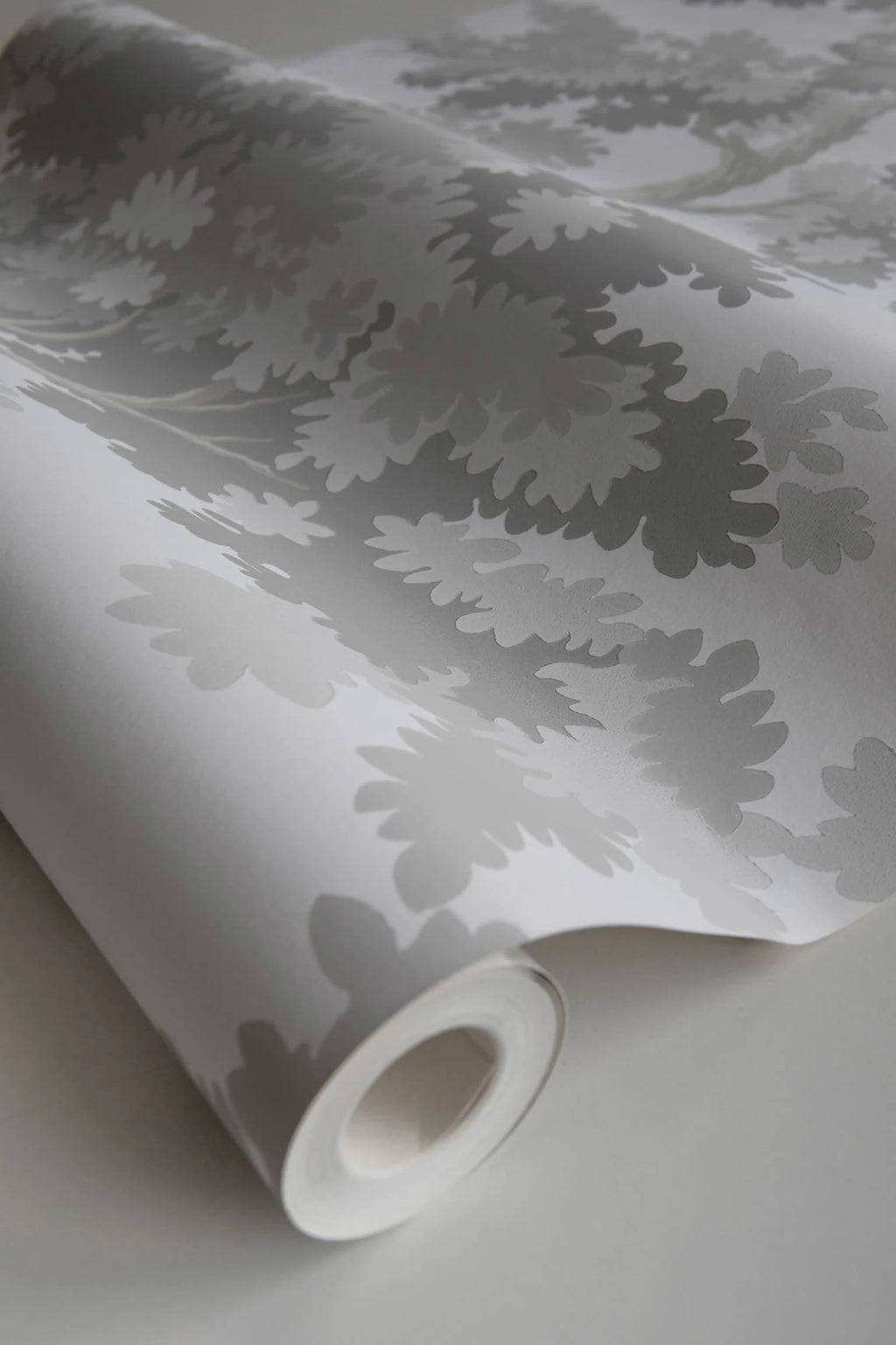 Raphael wallpaper by Sandberg, close-up of a part-rolled roll in soft grey oak-tree print