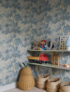 Raphael wallpaper by Sandberg in blue oak-tree print in a childrens room with shelves of toys and woven baskets