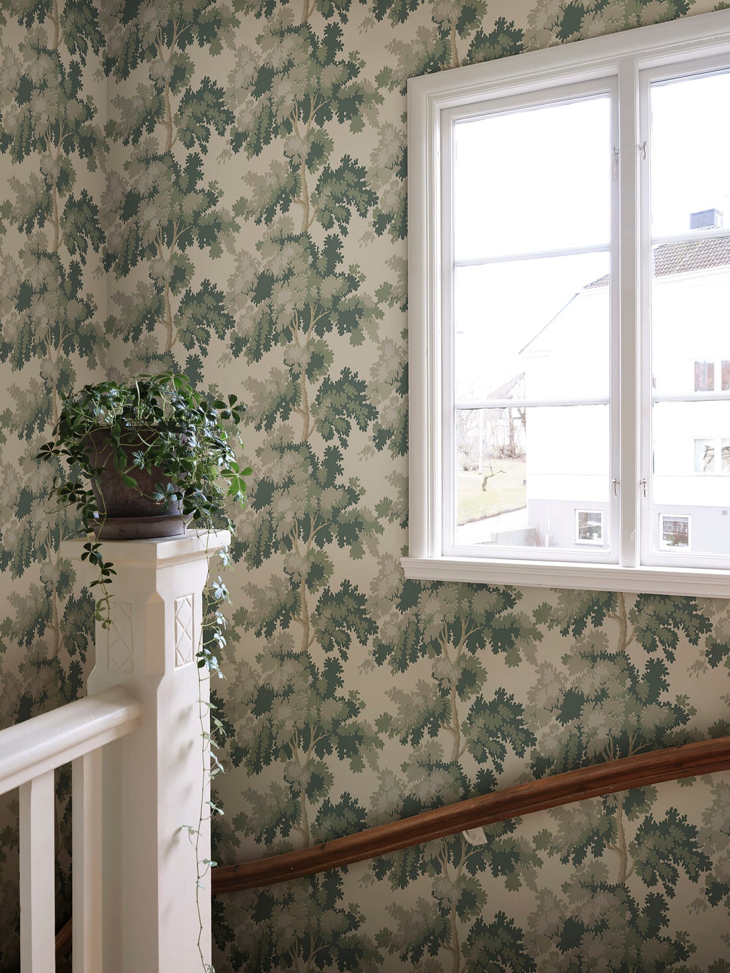 Raphael wallpaper by Sandberg in Green on a stair landing, with a white-framed window and painted banister