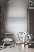 Gryning Dawn wall mural by Sandberg styled in a soft nursery with rattan crib, layered cushions and dusky pink curtain
