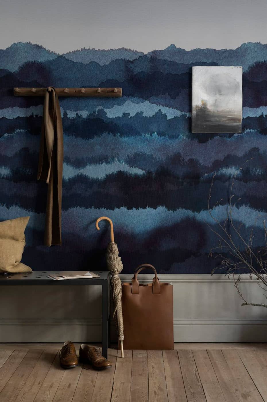 Midnatt wall mural by Sandberg in indigo blue watercolour hills, styled in a hallway with bench, coat hook and tan bag