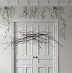 Aralia wallpaper by Sandberg in Moss Green, styled on an interior wall