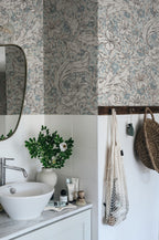 Mattias wallpaper by Sandberg in blue-grey floral design above white tiles in a bathroom with basin and mirror