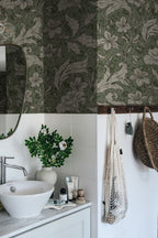 Mattias wallpaper by Sandberg in deep green, lily and acanthus design above white tiles in a styled bathroom