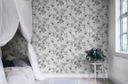 Sandra Floral wallpaper by Sandberg in cream, styled in a bedroom with the soft floral print behind a canopy bed and lilac flowers