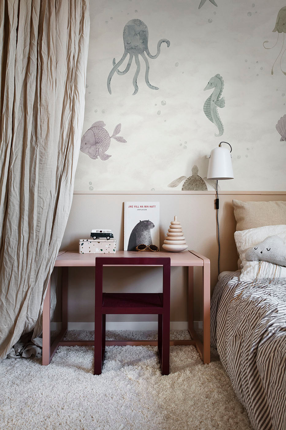 Alice Underwater wall mural by Sandberg in soft multicolour pastels, styled above a pink desk in a child's room