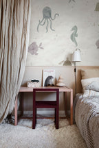 Alice Underwater wall mural by Sandberg in soft multicolour pastels, styled above a pink desk in a child's room