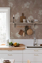 Poppy wallpaper by Sandberg in taupe, styled in a kitchen above a shelf with crockery, hanging boards and a wooden benchtop