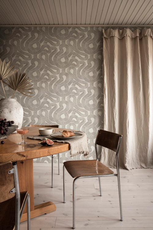 Zen wallpaper by Sandberg in charcoal looping print in a dining nook with a wooden table and linen curtain