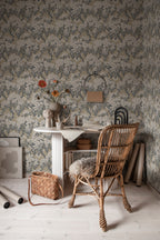 Ragnvi wallpaper by Sandberg in a home studio, blossom tree pattern behind a white desk, rattan chair and vase of poppies