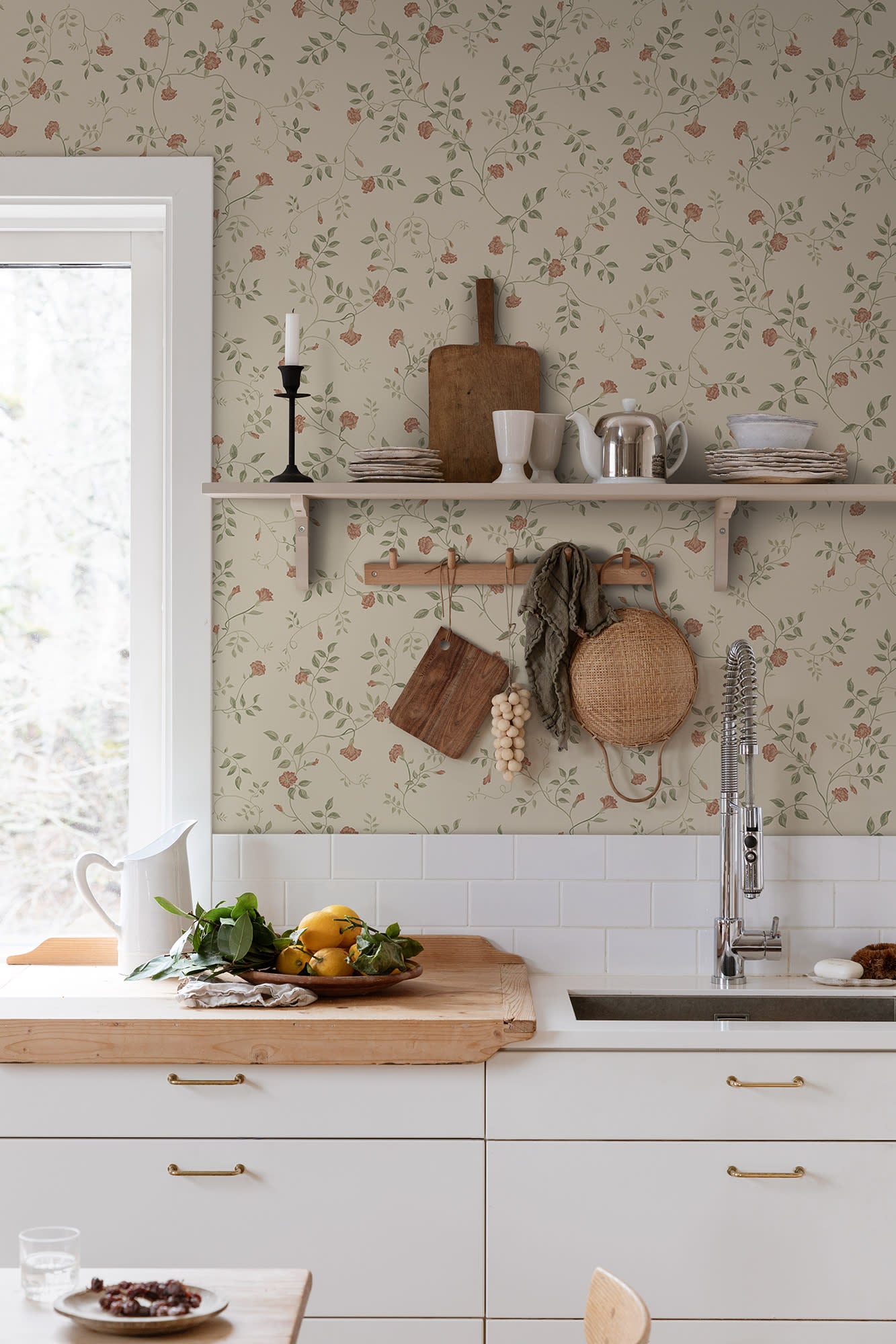 Henny wallpaper by Sandberg in a country kitchen, coral floral vine on sage behind open shelving and a sink