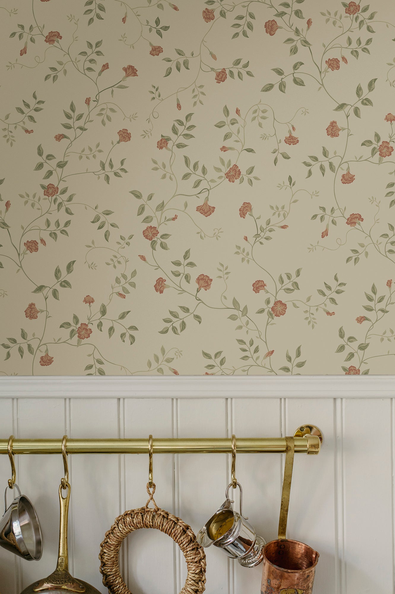Henny wallpaper by Sandberg above white panelling, coral carnation vine on cream with a brass utensil rail