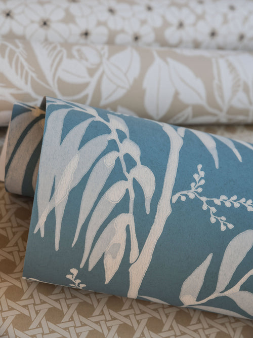 Casablanca Afternoon wallpaper by Långelid/von Brömssen in Smokey Blue - botanical design, behind a bolster cushion