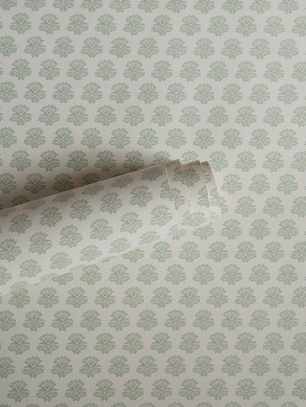 India wallpaper by Långelid/von Brömssen in Sage Green – floral design, a part-rolled length showing the block-print flower