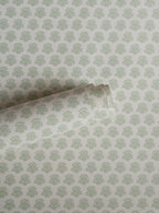 India wallpaper by Långelid/von Brömssen in Sage Green – floral design, a part-rolled length showing the block-print flower