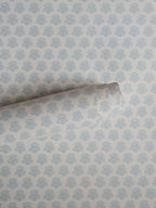 India wallpaper by Långelid/von Brömssen in Blue – floral design, a part-rolled length showing the block-print flower