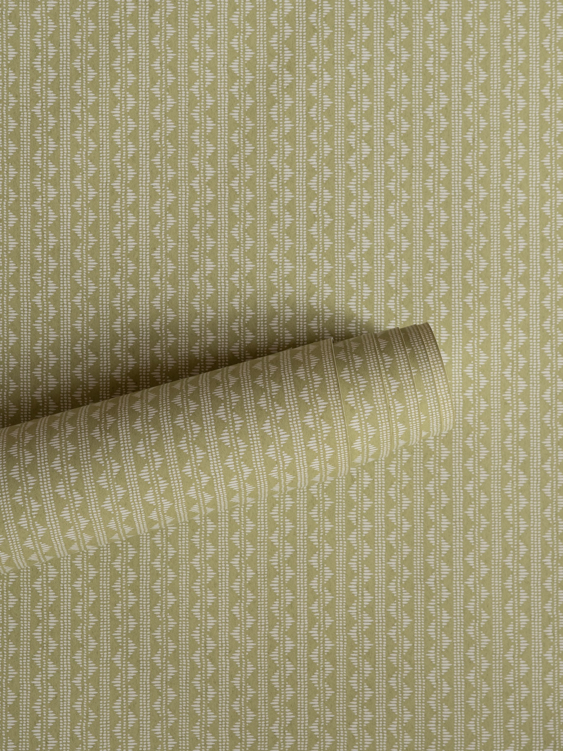Zigzag wallpaper by Långelid/von Brömssen in Green – Dusty Lemon – geometric design, a part-rolled length showing the woven zigzag