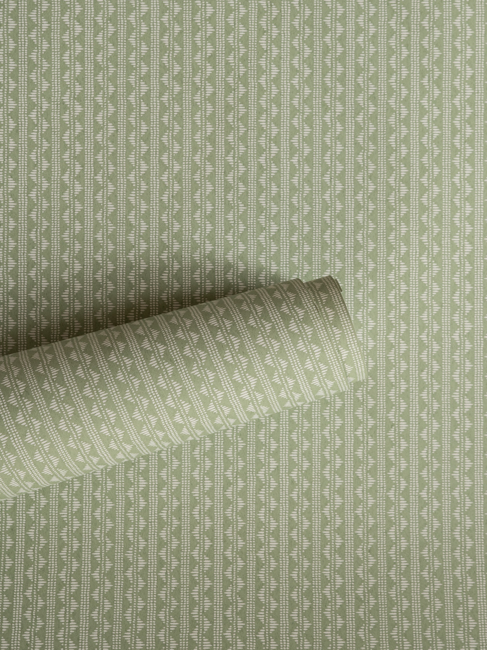 Zigzag wallpaper by Långelid/von Brömssen in Green – Laurel – geometric design, a part-rolled length showing the woven zigzag
