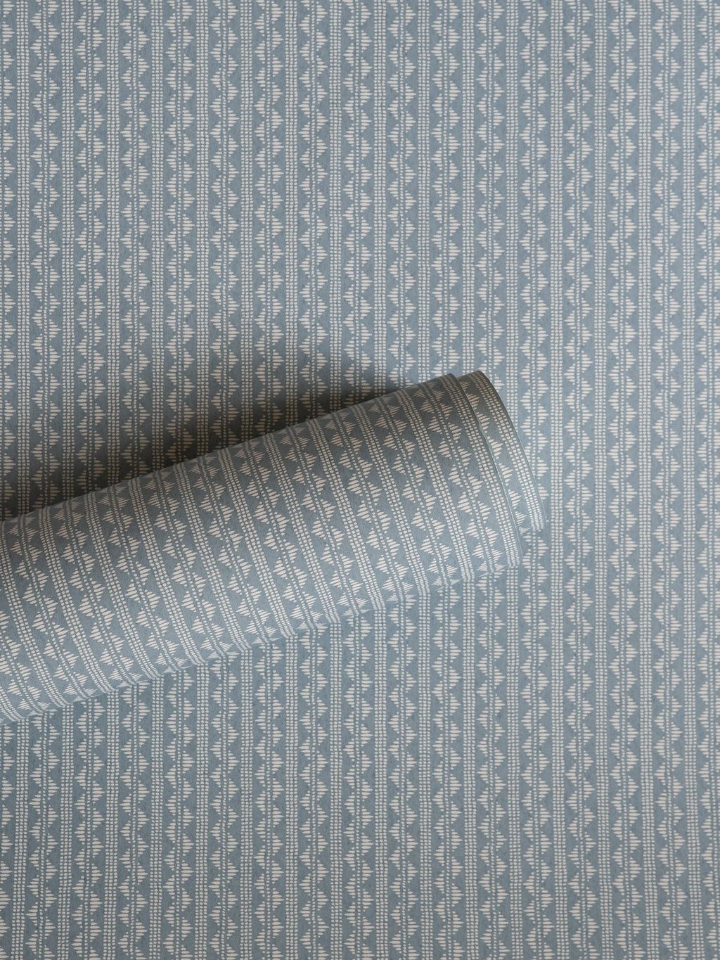 Zigzag wallpaper by Långelid/von Brömssen in Blue – geometric design, a part-rolled length showing the woven zigzag